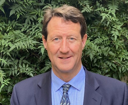 Photo of Julian Drinkall, announced as the new CEO to take post from 11 December 2023. Julian is wearing a dark blazer, blue shirt and tie.